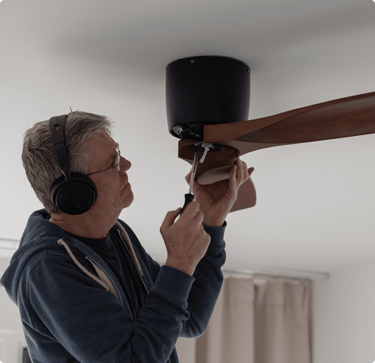 Individual repairing a ceiling fan