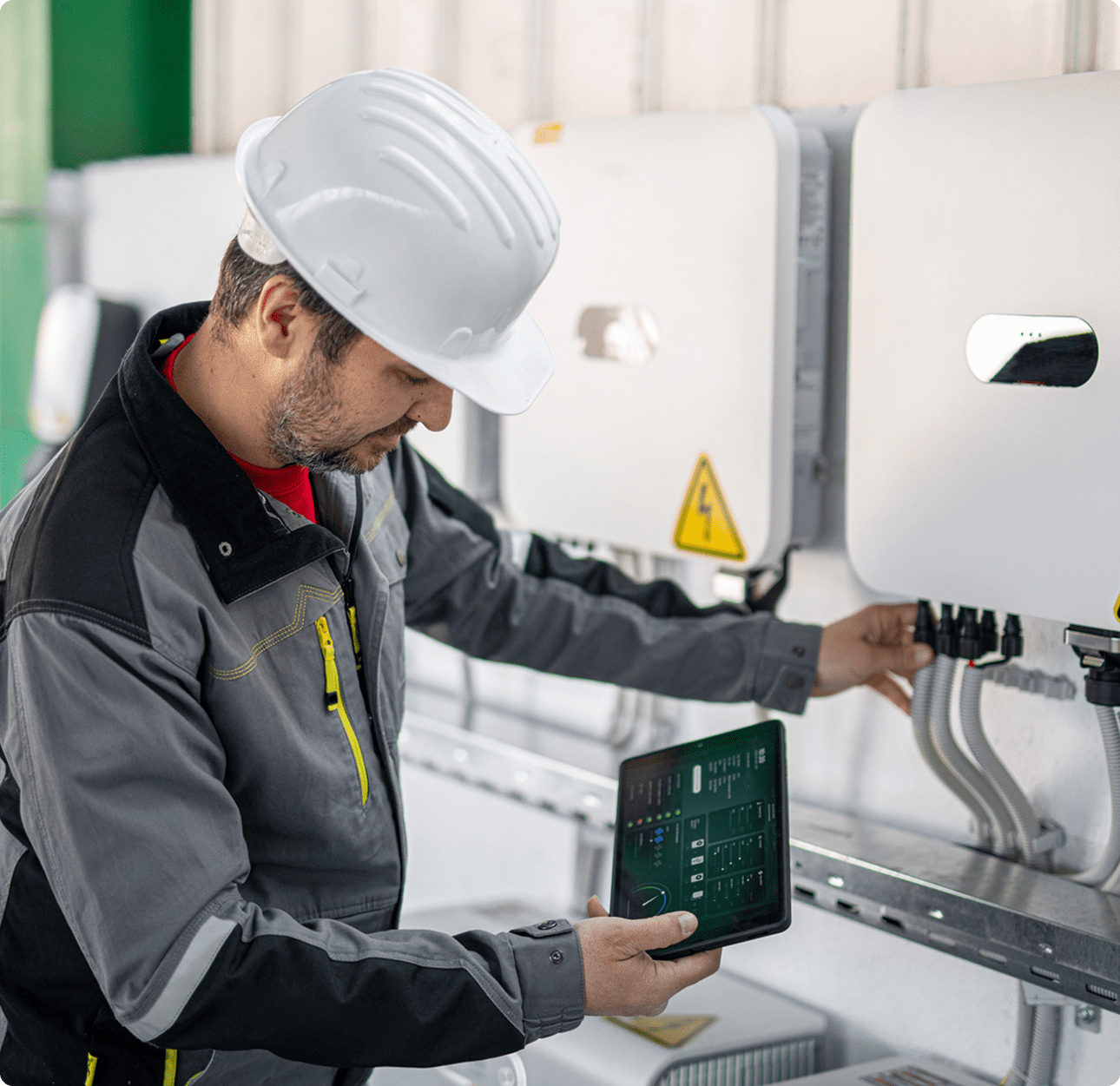 Technician inspecting industrial equipment with tablet