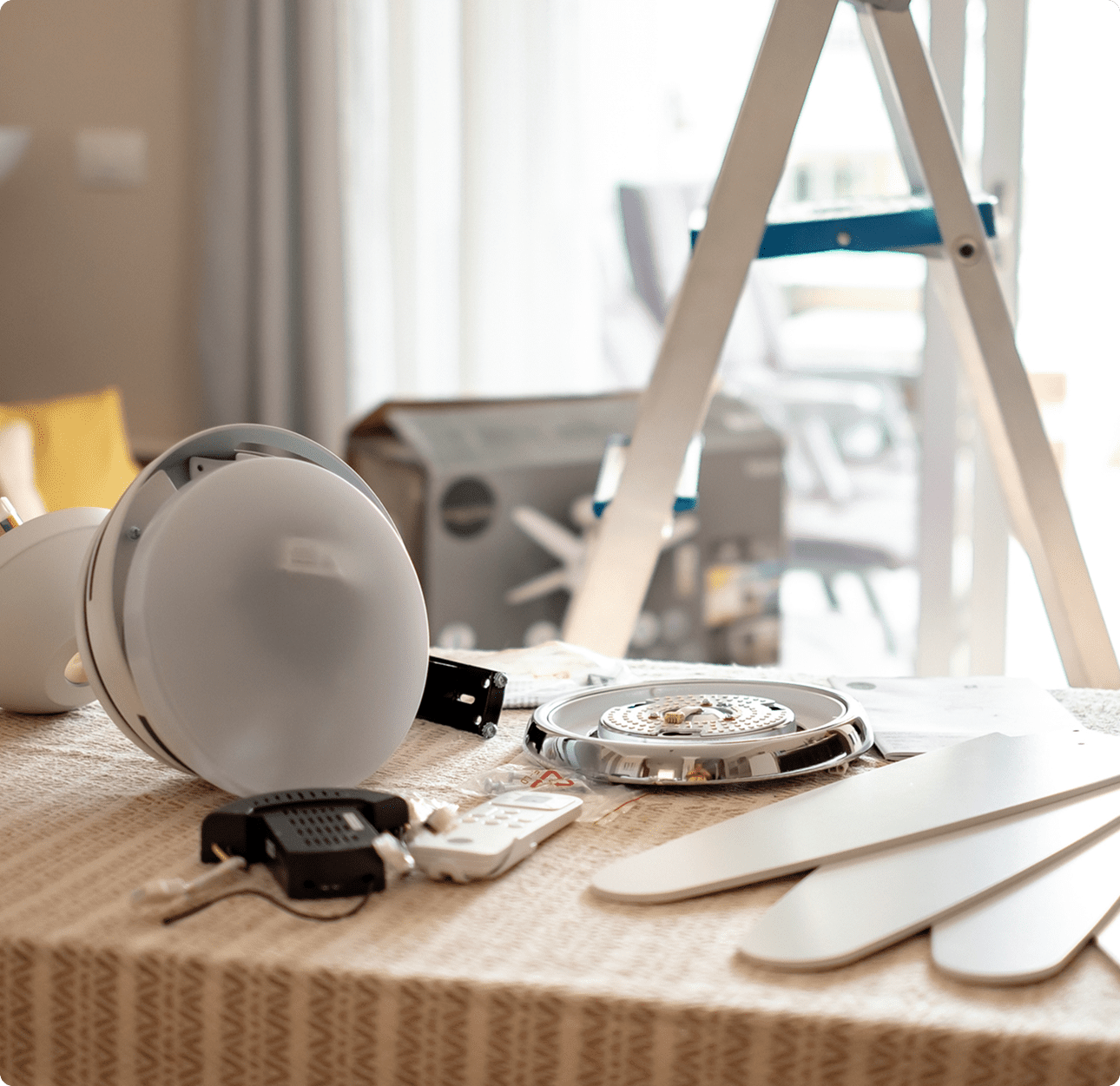 Ladder beside disassembled ceiling fan parts