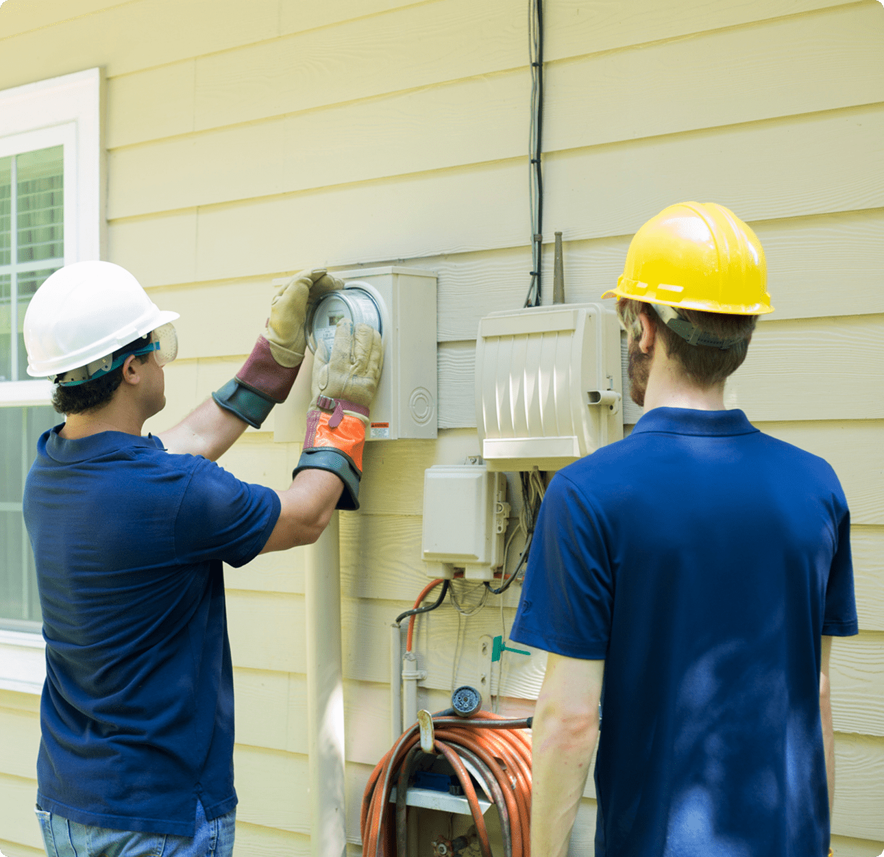 Workers checking residential power meter installation