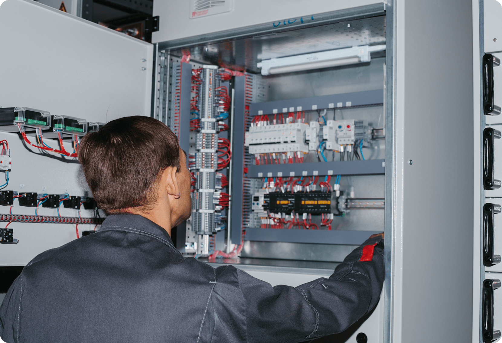 Technician inspecting electrical control panel